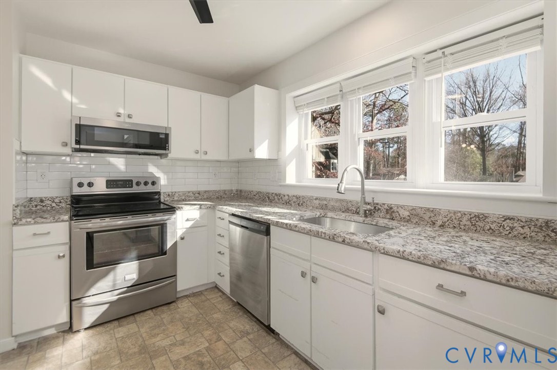 5600 Woods Walk Road Midlothian, VA 23112 - Photo 17 of 44 a kitchen with granite countertop white cabinets and window