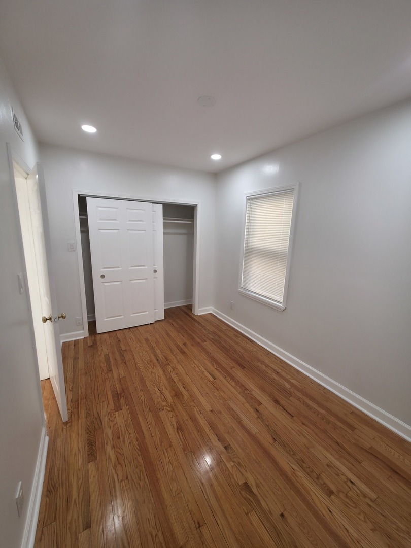 1748 North Keystone Avenue Chicago, IL 60639 - Photo 5 of 33 a view of empty room with wooden floor and window