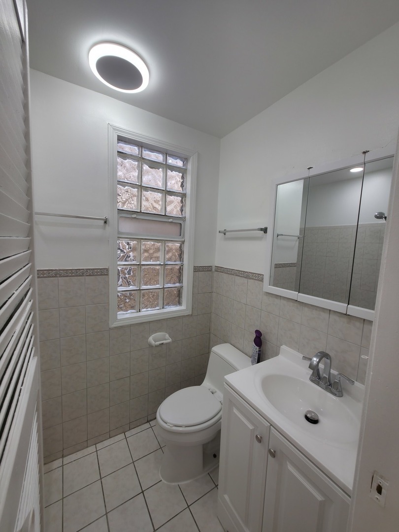 1748 North Keystone Avenue Chicago, IL 60639 - Photo 6 of 33 a bathroom with a toilet sink vanity and mirror