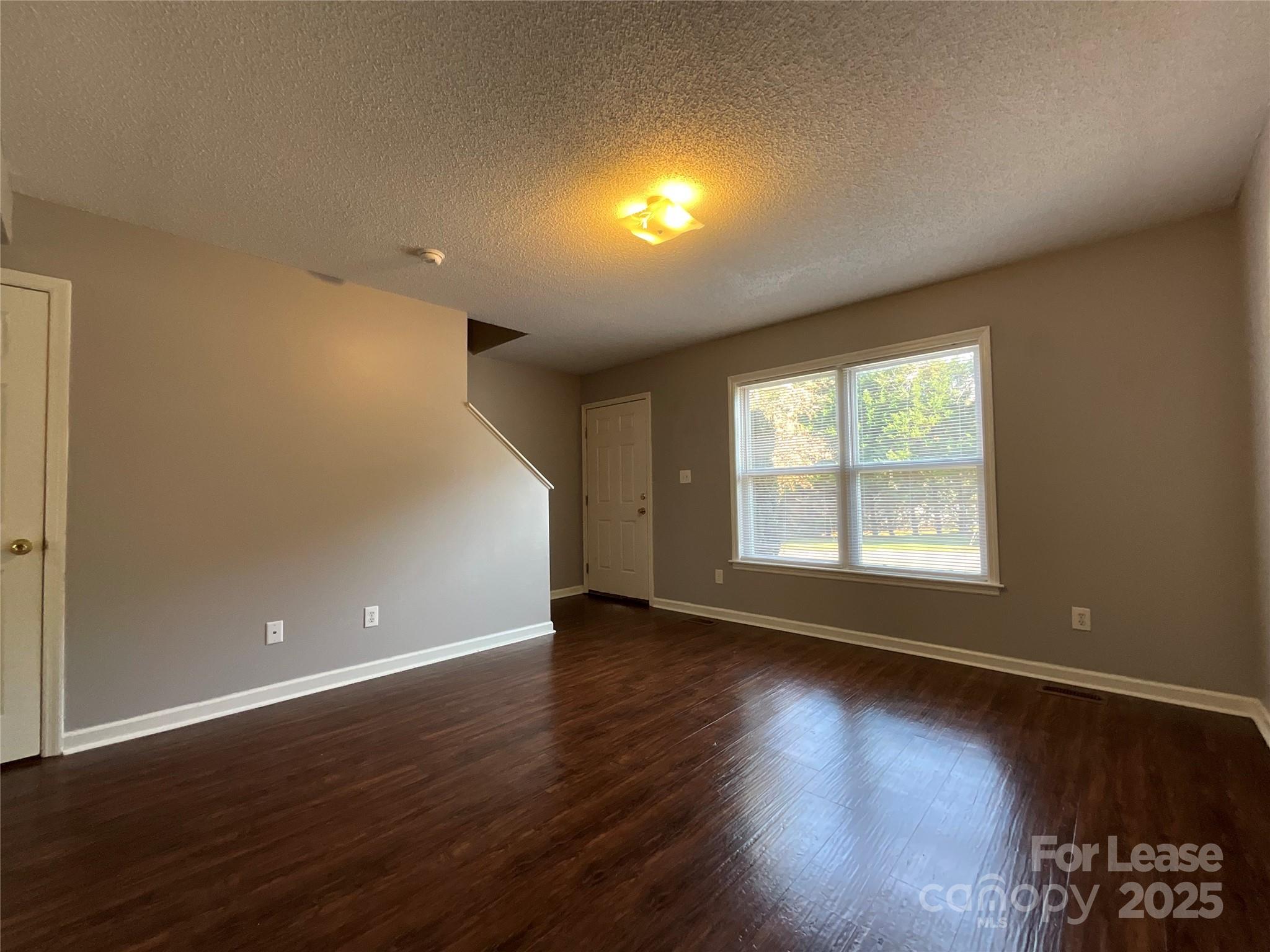 206 West 15th Street, Unit 3 Newton, NC 28658 - Photo 3 of 13 a view of an empty room with wooden floor and a window
