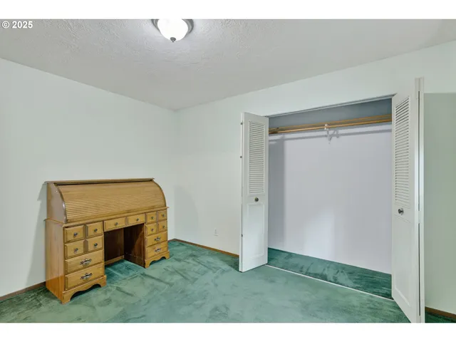 a view of an empty room with a fireplace and a window