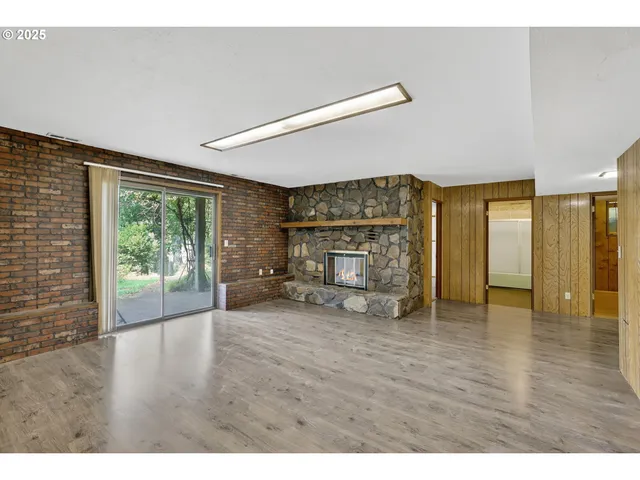 a view of empty room with wooden floor and fireplace