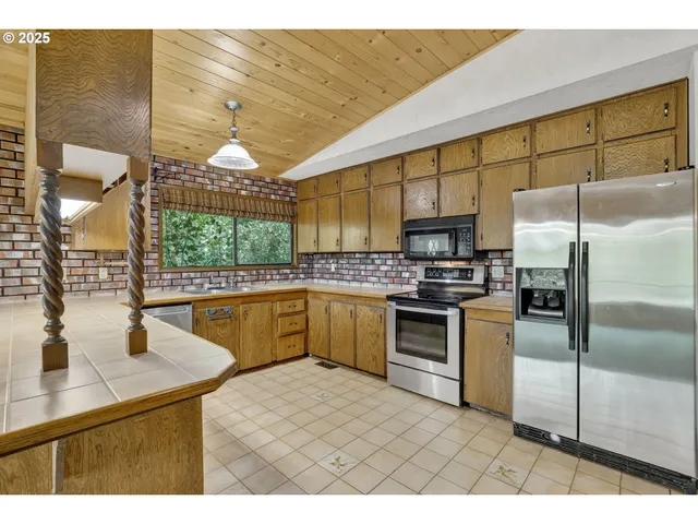 a kitchen with stainless steel appliances kitchen island granite countertop a sink a counter top space cabinets and stainless steel appliances