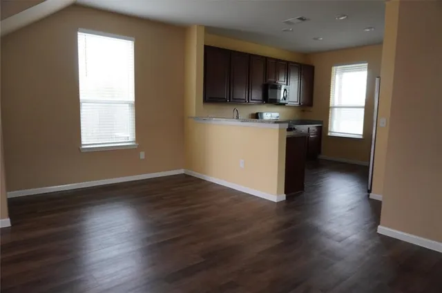 a kitchen with wooden floors and wooden cabinets