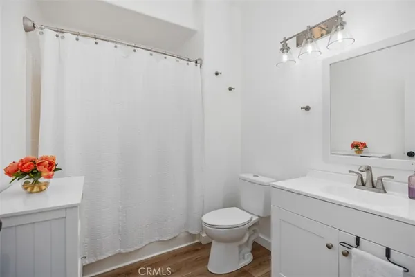 a bathroom with a sink vanity mirror and toilet