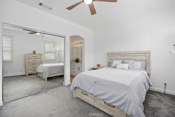 a spacious bedroom with a bed and a chandelier