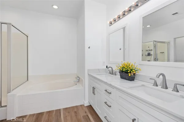 a bathroom with a granite countertop tub sink and mirror