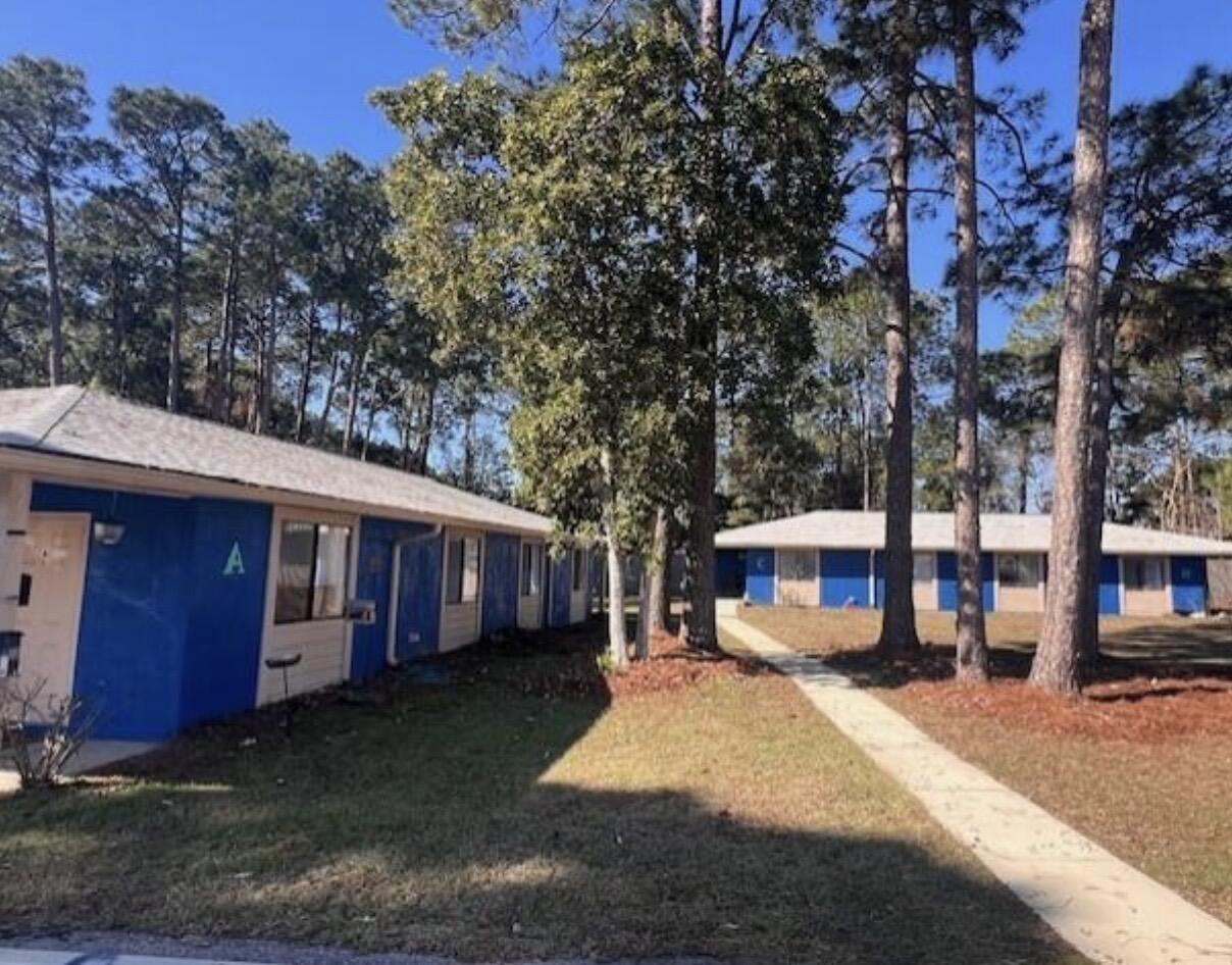 1925 Esplanade Street, Unit F Navarre, FL 32566 - Photo 2 of 13 a view of a house with a yard next to a road