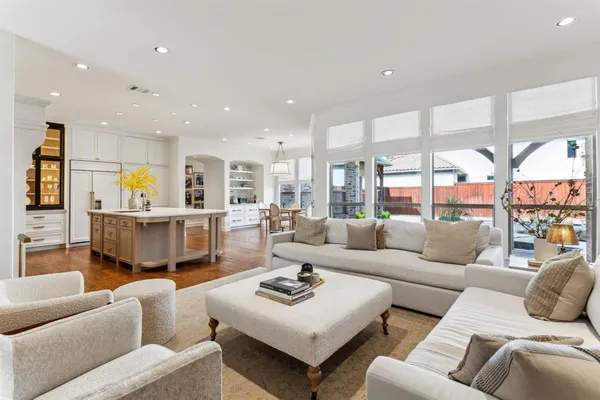 a living room with furniture kitchen view and a large window