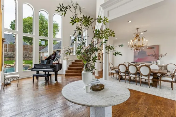 a dining room with furniture a chandelier and wooden floor
