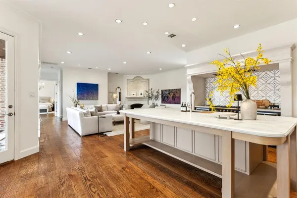 a large white kitchen with lots of counter space wooden floor and appliances