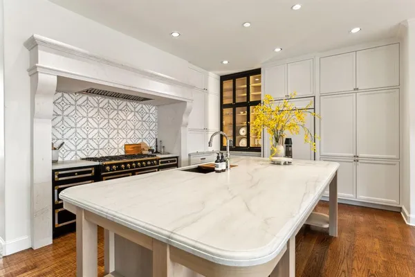 a kitchen with kitchen island a stove a counter space and a sink