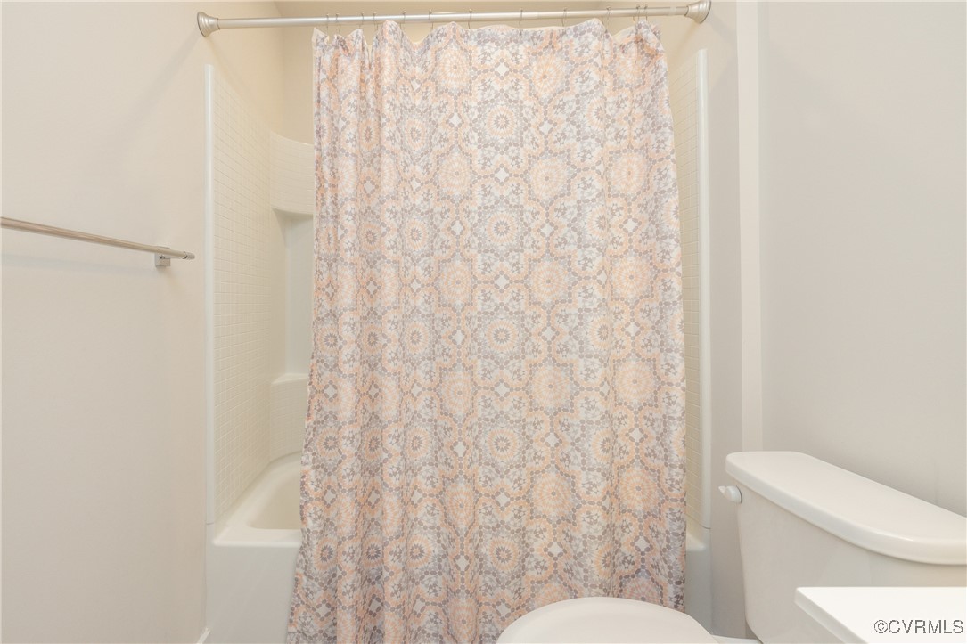 13900 Marsham Road Chester, VA 23836 - Photo 32 of 46 a white toilet sitting next to a shower curtain