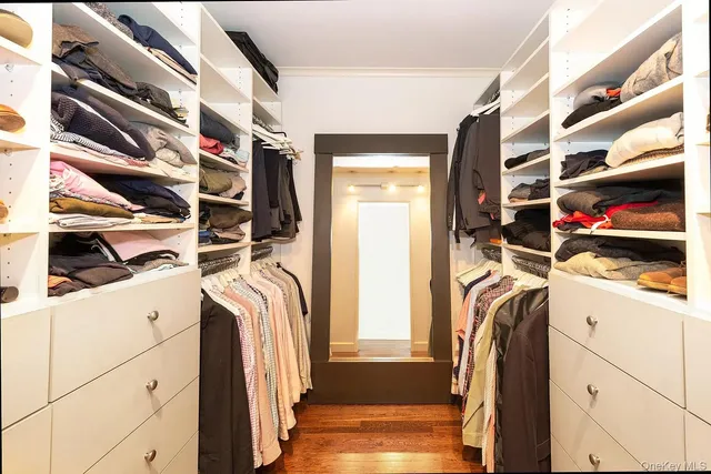 a view of walk in closet with clothes and shoes