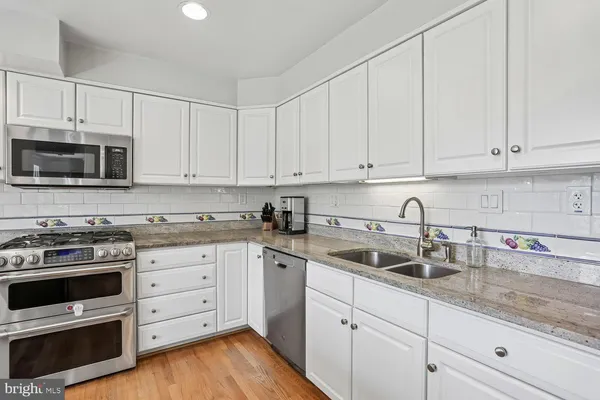a kitchen with appliances a sink and cabinets