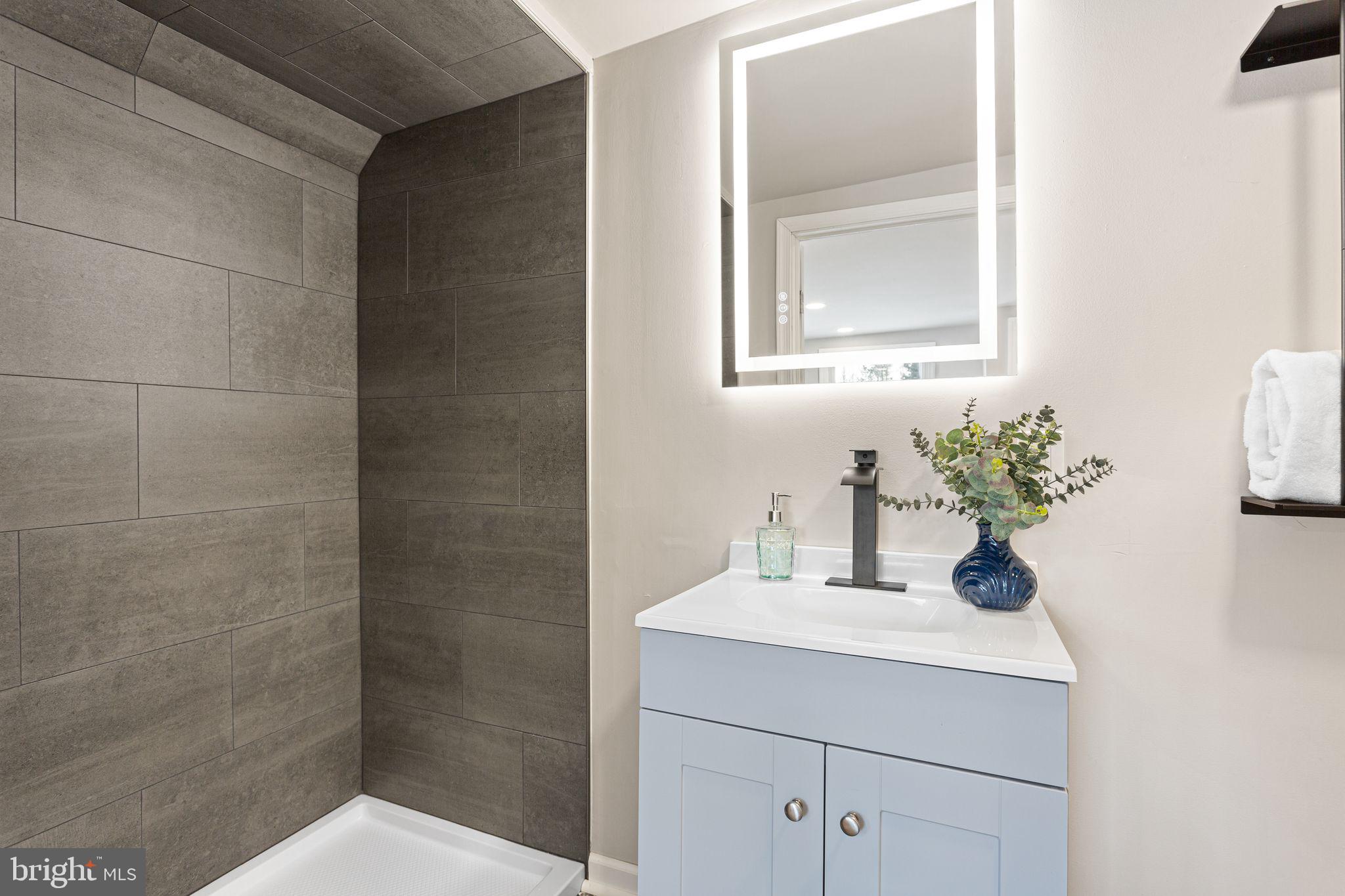 595 Church Road Sewell, NJ 08080 - Photo 17 of 32 a bathroom with a sink a mirror and a shower