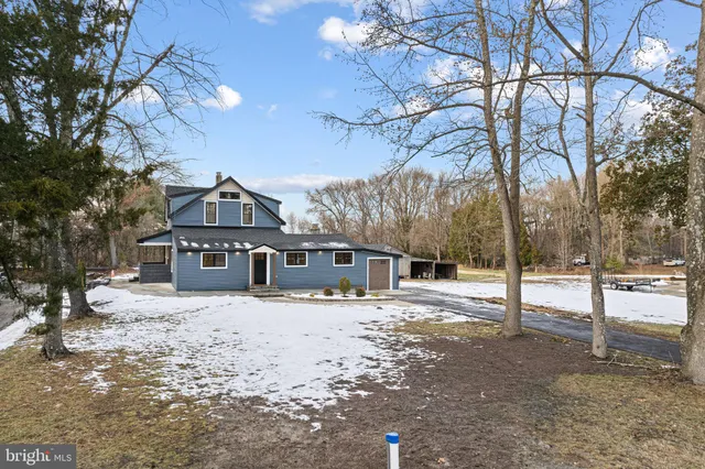 a front view of a house with a yard covered in snow