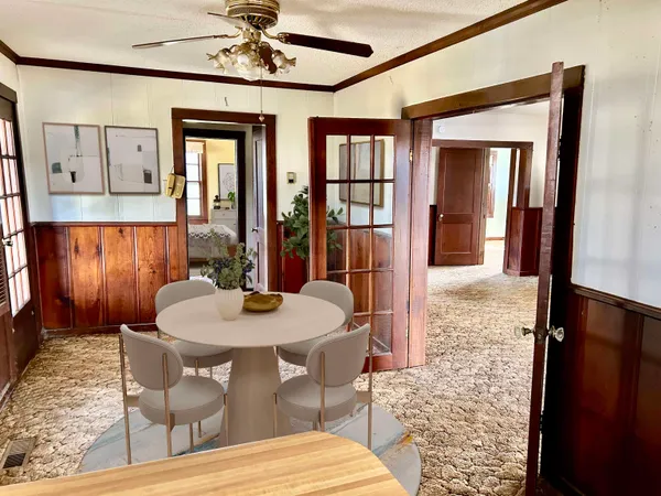 a dining room with furniture a chandelier and wooden floor
