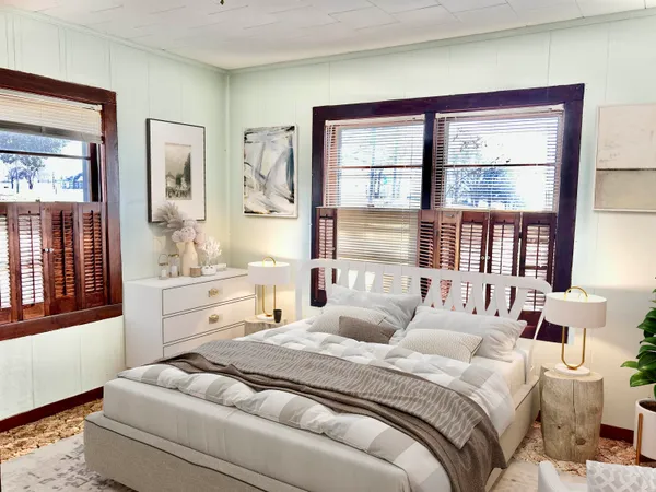a bedroom with a bed wooden floor and window