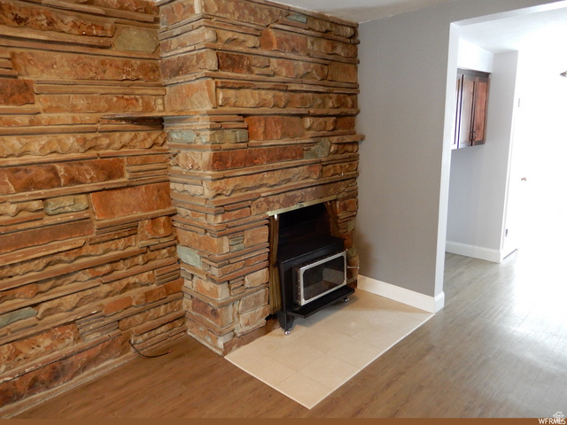 490 Averett Avenue Springville, UT 84663 - Photo 5 of 14 Stone-clad fireplace featuring a wood-burning insert and a hearth with light-toned tile