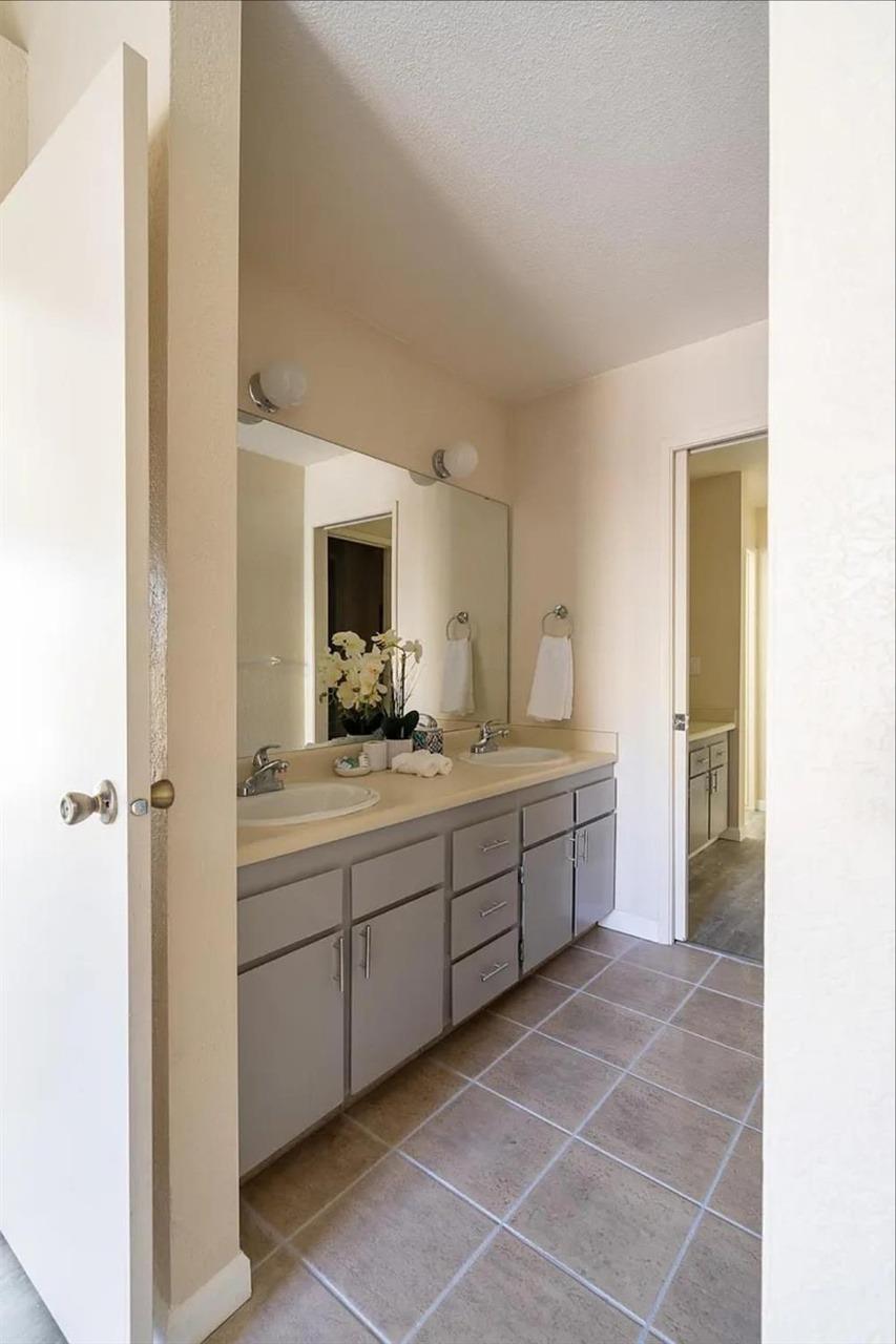 1504 Pierce Drive, Unit 102 Clovis, CA 93612 - Photo 14 of 20 a spacious bathroom with a mirror and a sink