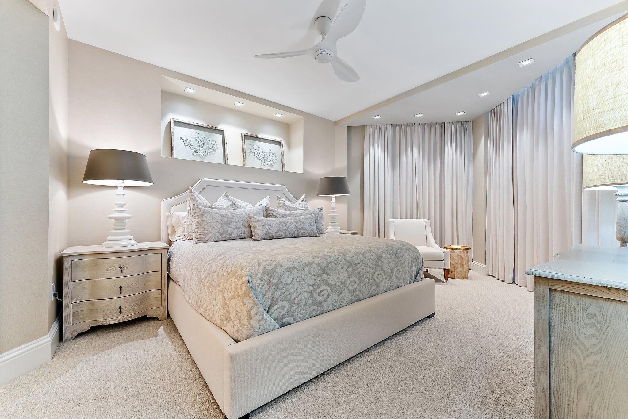 2700 North Ocean Drive, Unit 2304B Singer Island, FL 33404 - Photo 25 of 73 a spacious bedroom with a bed and a lamp