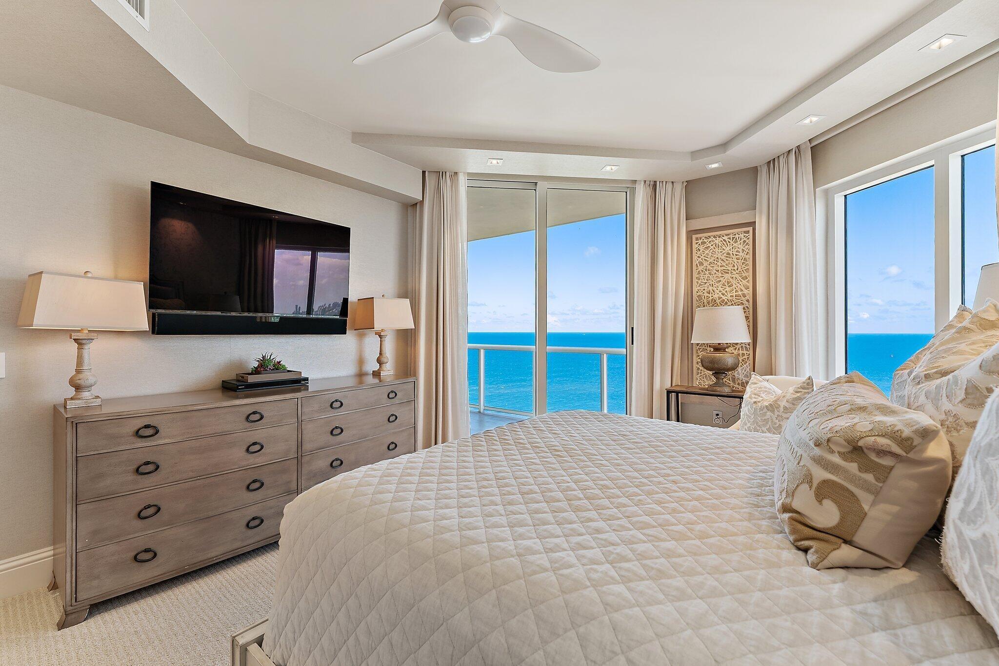2700 North Ocean Drive, Unit 2304B Singer Island, FL 33404 - Photo 35 of 73 a bedroom with a large bed and a flat tv screen on dresser