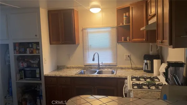 a kitchen with stainless steel appliances granite countertop a sink stove and cabinets