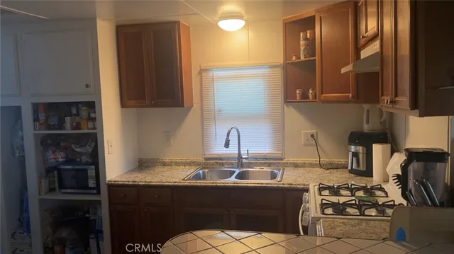 a kitchen with stainless steel appliances granite countertop a sink stove and cabinets