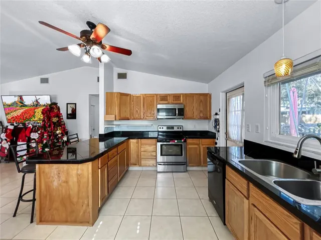 a kitchen with stainless steel appliances a sink and a wooden floor