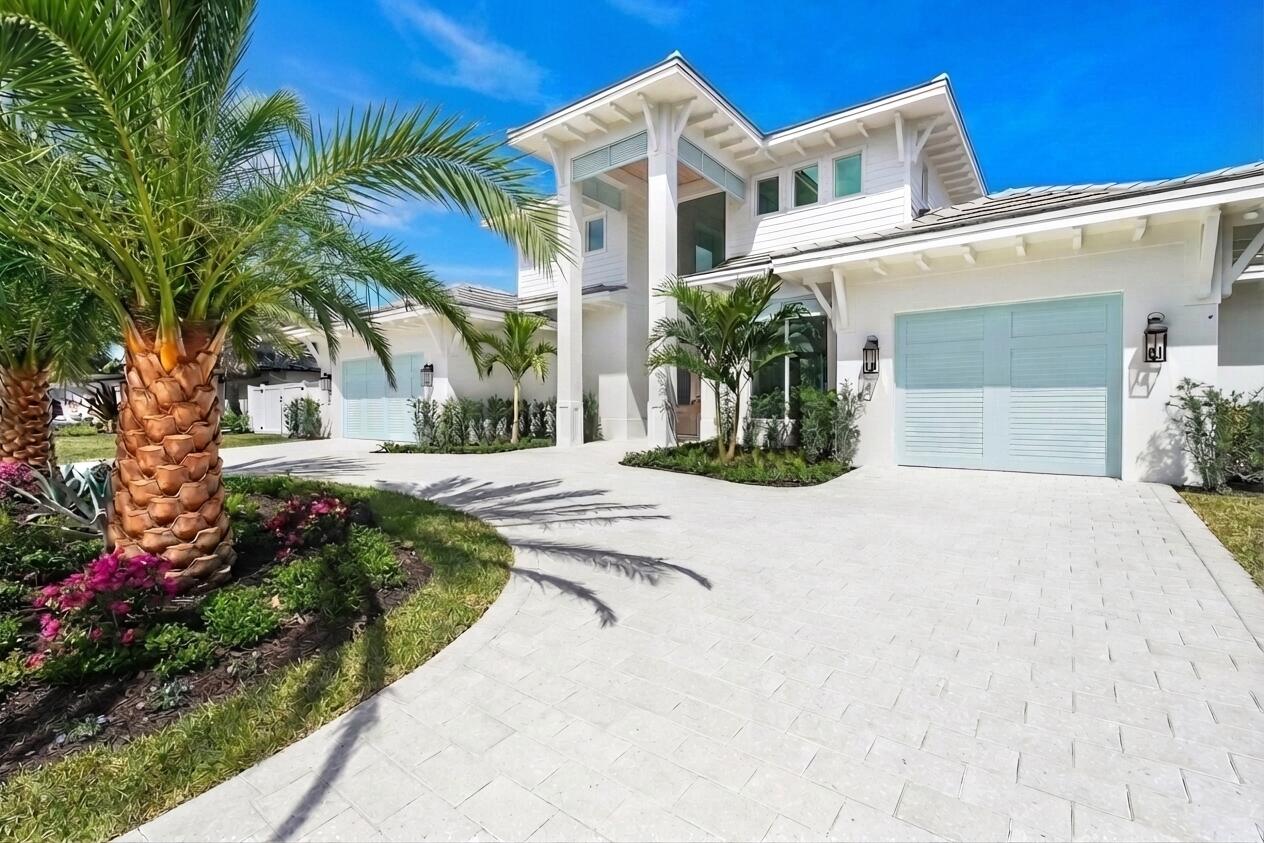 192 River Drive Jupiter, FL 33469 - Photo 2 of 45 a view of a white house with a yard and potted plants