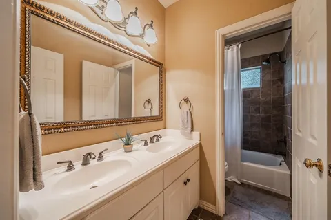 a bathroom with a tub a sink and mirror