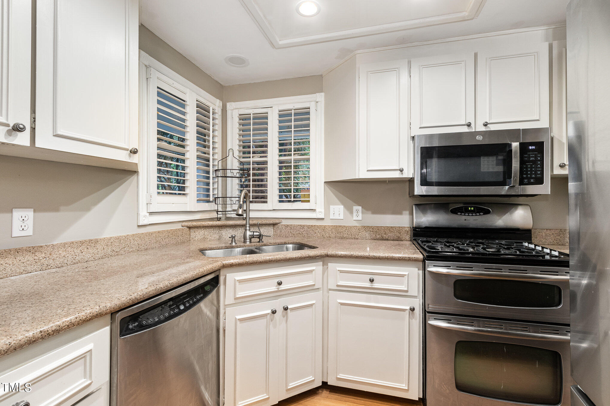 7831 Breckon Way Raleigh, NC 27615 - Photo 11 of 29 a kitchen with granite countertop a sink cabinets stainless steel appliances and a window