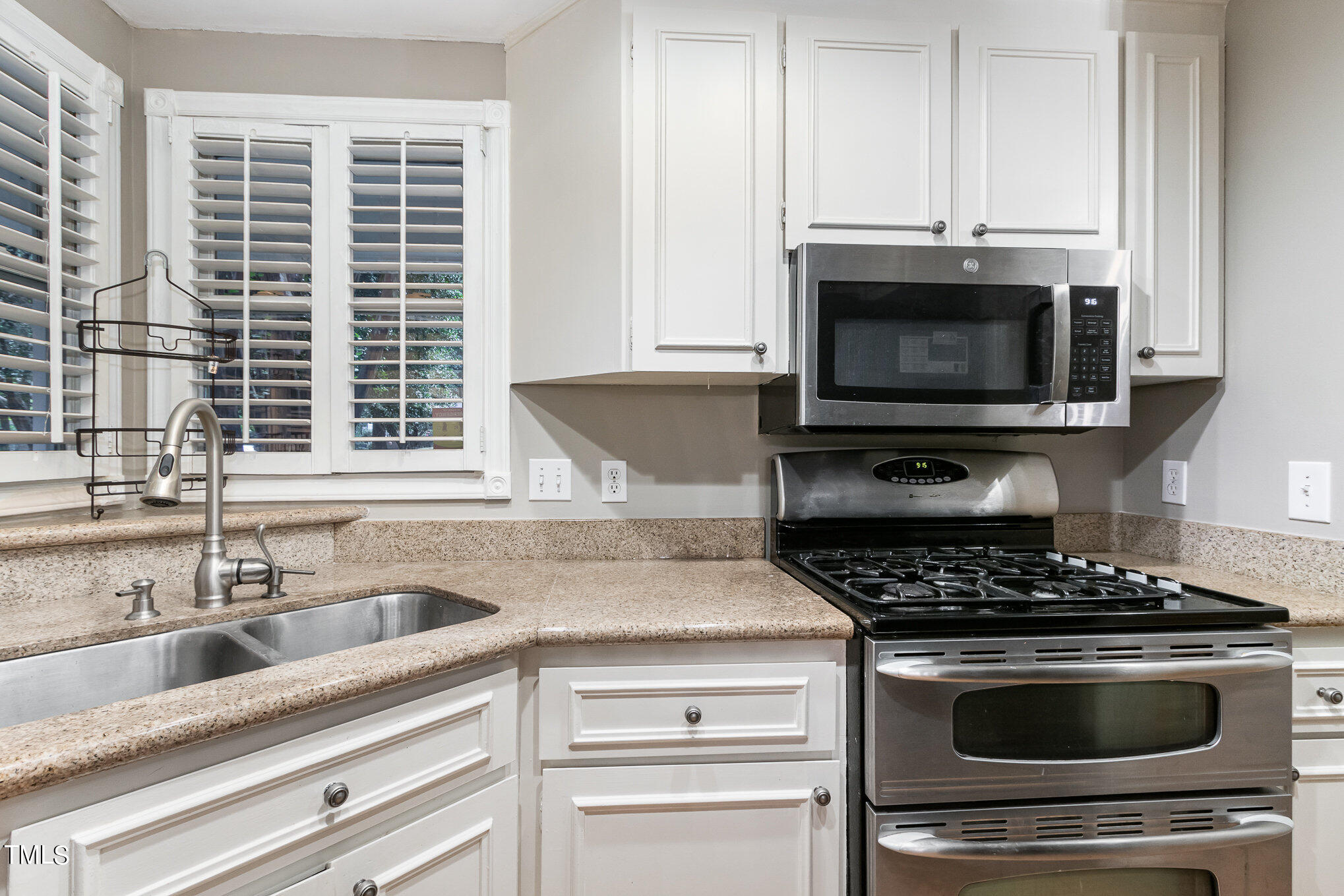 7831 Breckon Way Raleigh, NC 27615 - Photo 12 of 29 a kitchen with granite countertop a stove and a sink