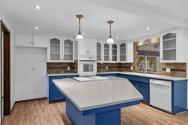 a kitchen with stainless steel appliances granite countertop a sink a stove and a wooden floors