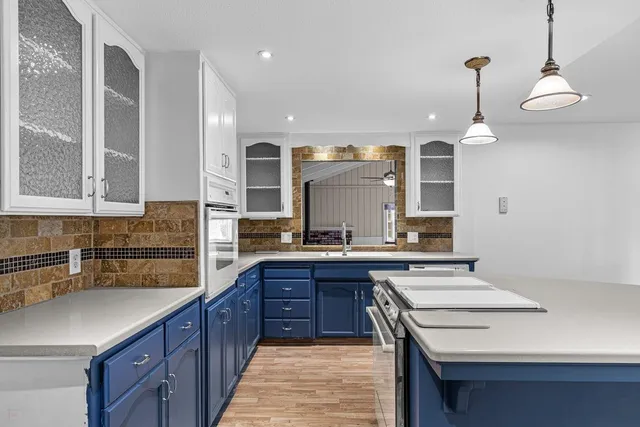 a kitchen with a sink stove and wooden cabinets