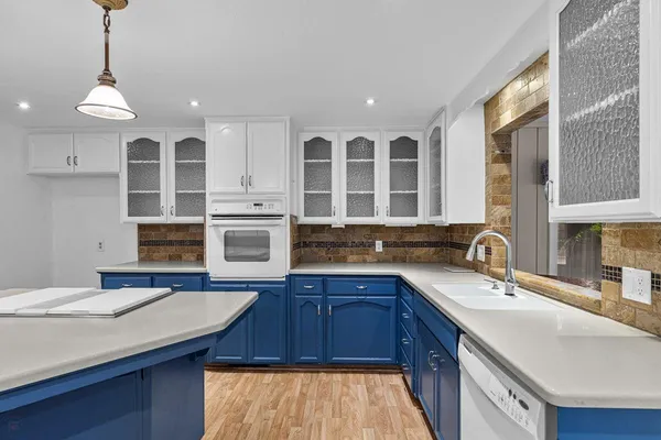 a kitchen with stainless steel appliances a sink a stove and a wooden cabinets
