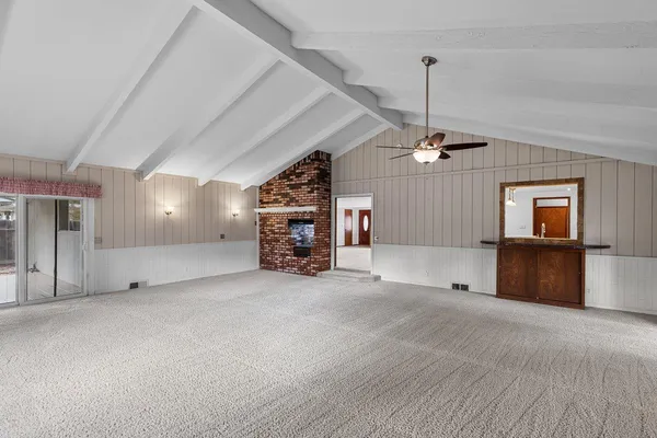 an empty room with fireplace and windows