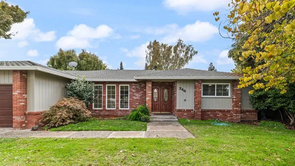 a front view of a house with a garden and yard
