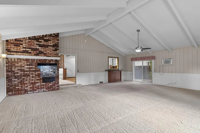 an empty room with a window and a ceiling fan