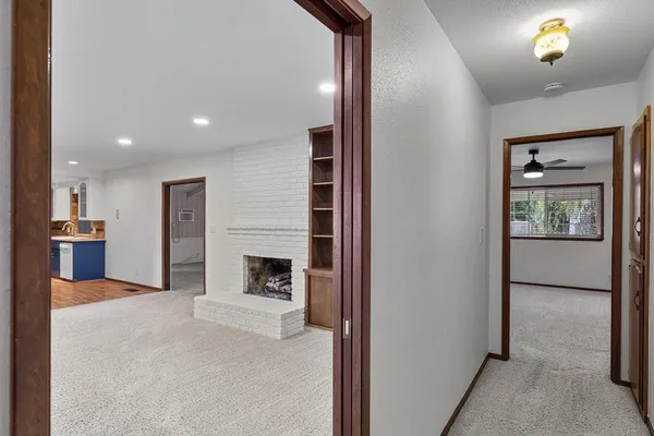 a view of an empty room and a ceiling fan window