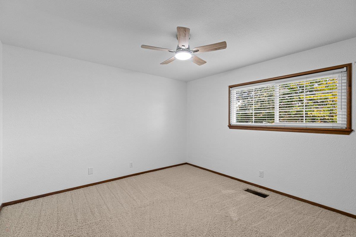 244 California Street Ripon, CA 95366 - Photo 27 of 34 an empty room with a window and a ceiling fan