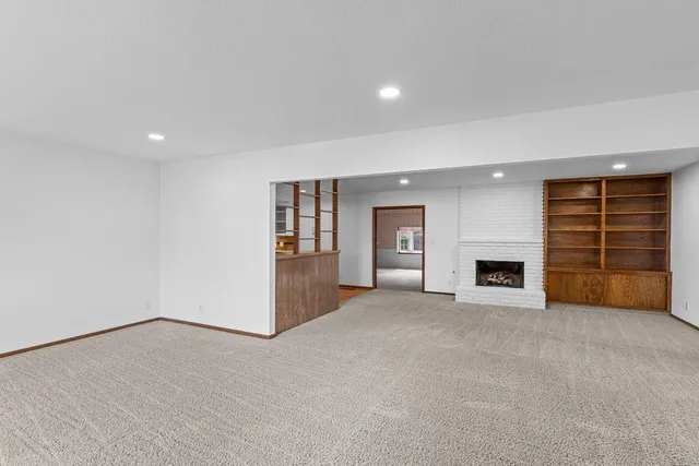 an empty room with furniture and fireplace