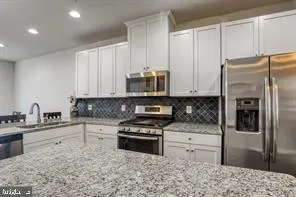 a kitchen with granite countertop a refrigerator sink and stove