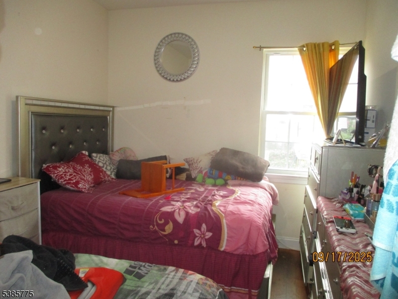 63 Warwick Street Newark, NJ 07105 - Photo 3 of 17 a bedroom with two beds and a large window