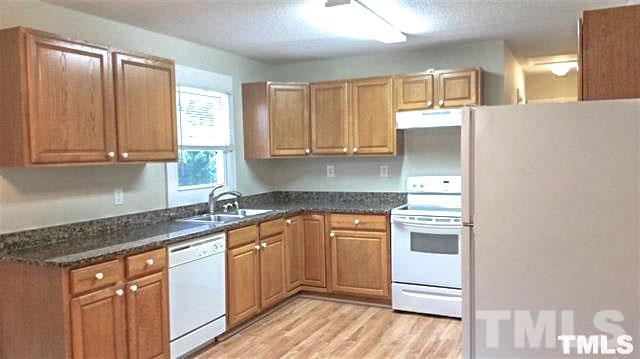 3026 Hamlin Road Durham, NC 27704 - Photo 7 of 15 The open kitchen has room for a table, and features beautiful oak cabinets in a warm honey finish with elegant dark granite counter tops and updated appliances.