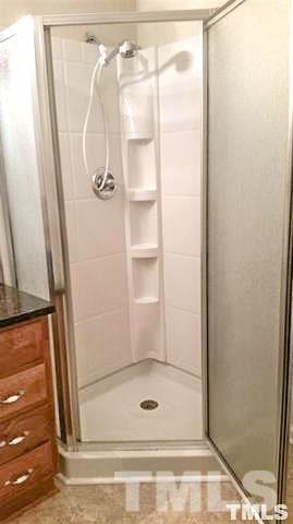 3026 Hamlin Road Durham, NC 27704 - Photo 8 of 15 The glassed-in shower has built-in storage and a convenient hand-held shower head.