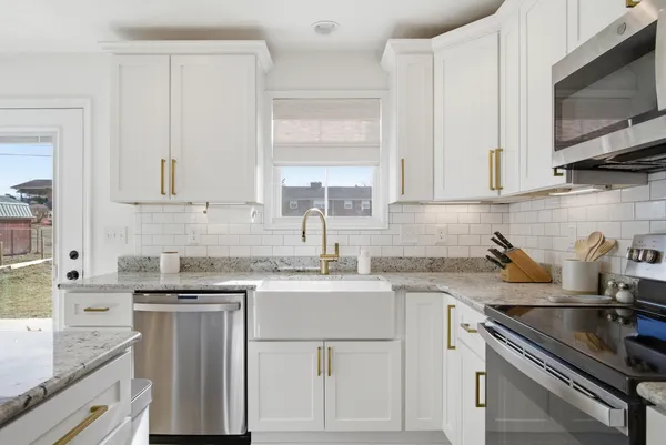 a kitchen with cabinets appliances a sink and a counter top space