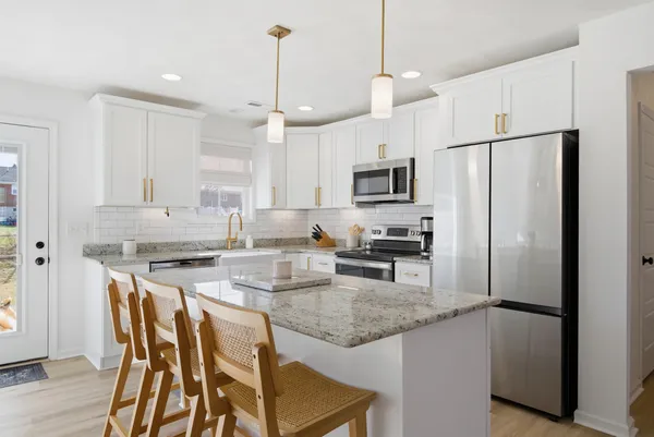 a kitchen with kitchen island granite countertop a sink a center island and stainless steel appliances
