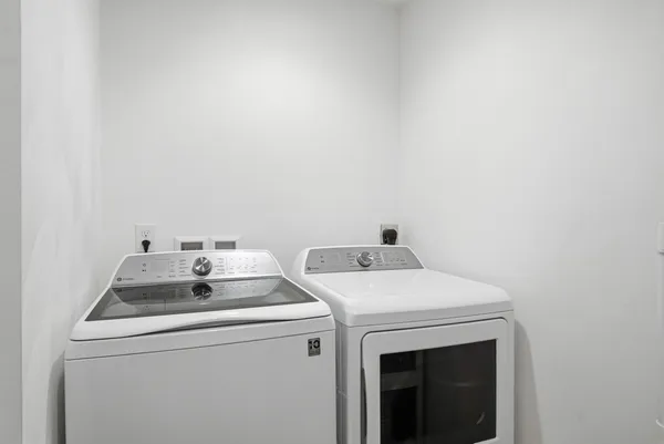 a utility room with fridge and sink